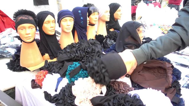 4K Arranging heads of dummies covered in scarfs on the market