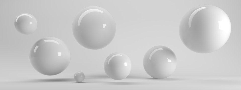 3d rendering of several sized reflected spheres inside a white studio