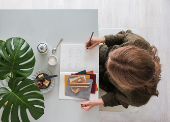 Frau zeichnet Mode in ihrem Atelier