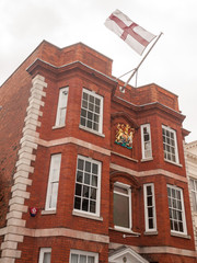 Fototapeta na wymiar Stock Photo - front of red brick building england flag top harwick uk