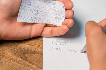 People cheating on test by wrote answer on piece of paper