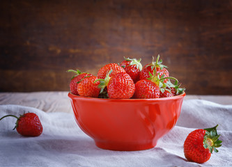 Strawberries in a red bowl .