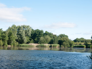 Obraz premium Stock Photo - lake surface top with trees and sky outside wivenhoe essex england uk