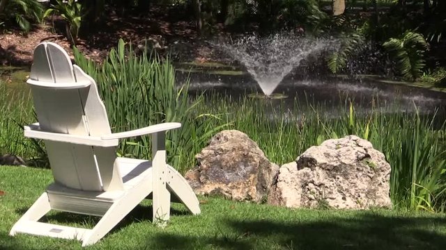 Relaxing garden setting with Adirondack chair and water feature 