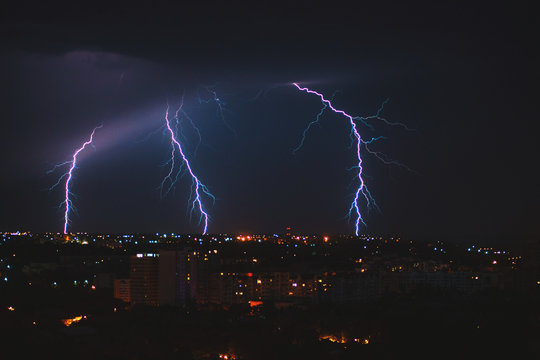 Photo of beautiful powerful lightning over big city, zipper and thunderstorm, abstract background, dark blue sky with bright electrical flash, thunder and thunderbolt, bad weather concept