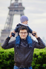 Father holding his son on shoulders near the Eiffel tower