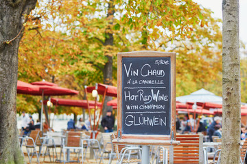 Fototapeta na wymiar Menu board with words 'hot wine' in three languages in Parisian outdoor cafe