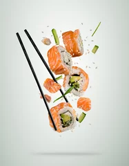 Fototapeten Flying sushi pieces with chopsticks, separated on soft background © Jag_cz