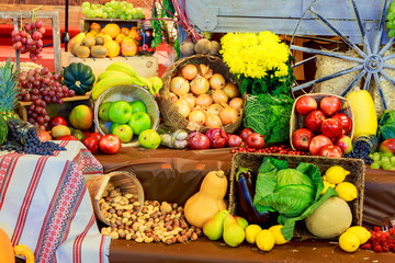 Set ripe healthy foods consisting of vegetables and fruits lying on the wooden table closeup