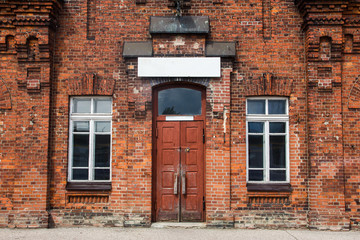 Old vintage red brick wall building. Wooden door entrance.
