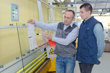 manual worker and businessmen with documents at warehouse