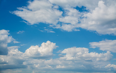 White curly clouds in a blue sky. Sky background