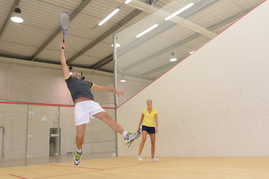 couple playing indoors tennis court