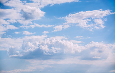 White curly clouds in a blue sky. Sky background