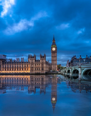 View of the Houses of Parliament and Westminster Bridge in London after duks with clear reflection