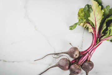 Fresh organic farmer raw beets with leaves on a white marble kitchen table. Top view copy space