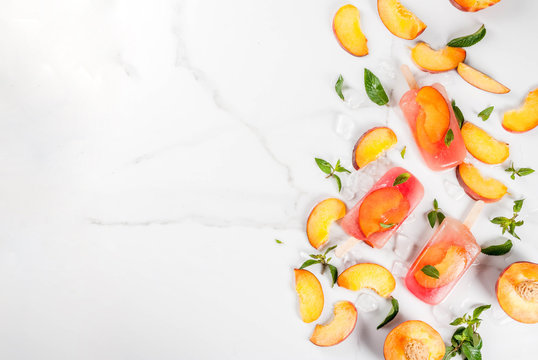 Summer Desserts. Frozen Drinks. Sweet Fruit Popsicles From Frozen Peach Tea With Mint. On A White Marble Table, With Ingredients - Peaches, Mint, Ice. Copy Space Top View