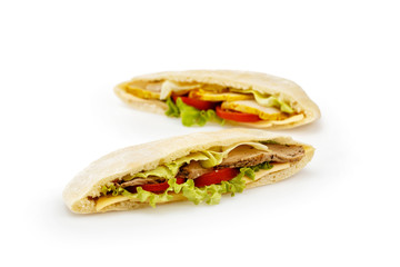 Two pieces of pita bread with meat and vegetables