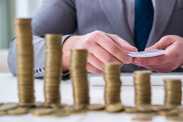 Businessman with golden coins in business growth concept