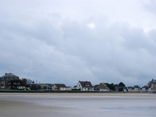 Normandy beach town low tide storm clouds