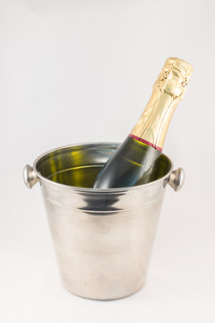 Botella de champán y cubitera sobre fondo blanco
