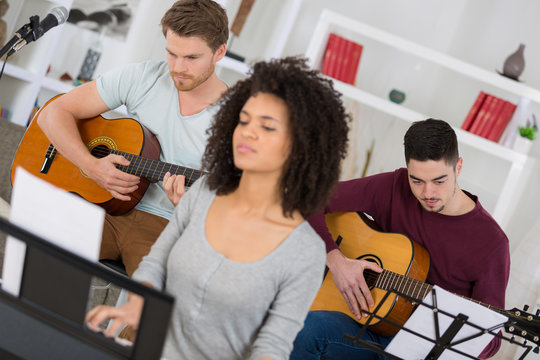 group of young friends playing the guitar