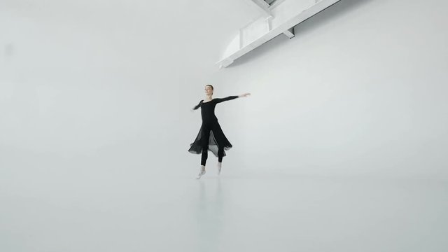 Shapely 20s dancer girl in black beautifully dances in front of a large window in white ballroom 20s 1080p slow motion