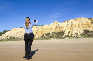 woman making photos on the cliff of the asperillo
