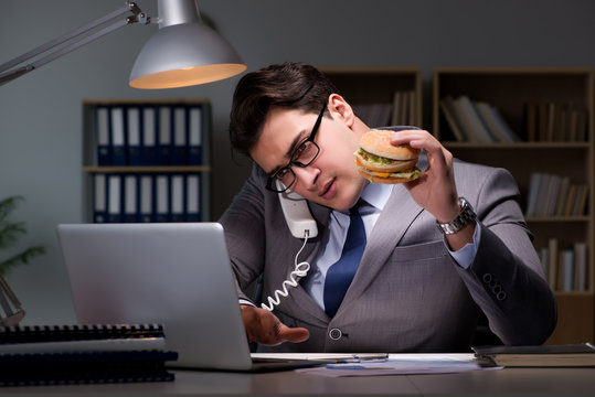 Businessman Late At Night Eating A Burger