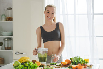 Young woman making detox smoothie at home