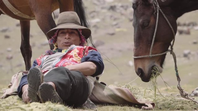 Peruvian muleteer resting near horse wearing the typical costume of the highlands. Slow motion	