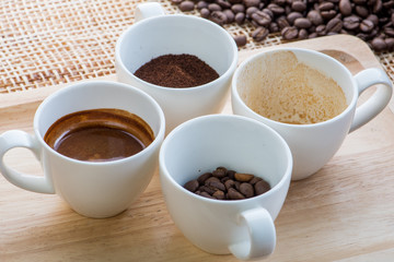 Cup of coffee on coffee beans background on a wooden table