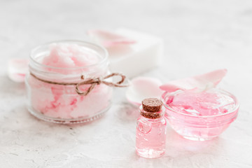 Obraz na płótnie Canvas cosmetic set with rose blossom and body cream on white desk background