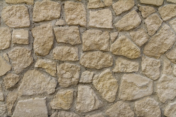 Stone wall background. Rock textured surface. Rough material. Horizontal view
