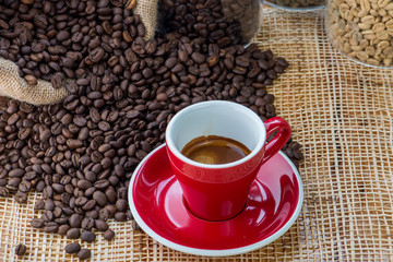 Cup of coffee on coffee beans background on a wooden table