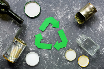 Garbage for recycling with recycling symbol on grey table background top view