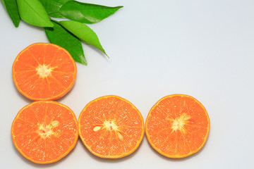 Orange mandarin or tangerine fruits, with green leaves on white background.