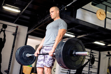 Obraz na płótnie Canvas Attractive man is lifting weights