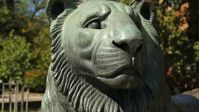 Big statue of lying lion on street in city, depiction of animals, symbolism