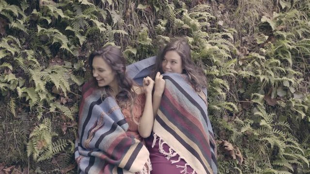 Playful Young Women Share A Blanket In The Forest, They Hide Behind It And Laugh 
