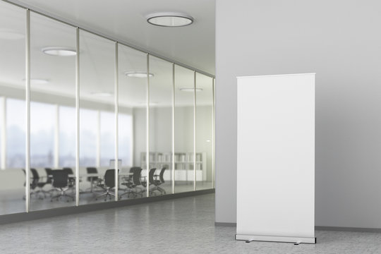 Blank roll up banner stand in modern office interior