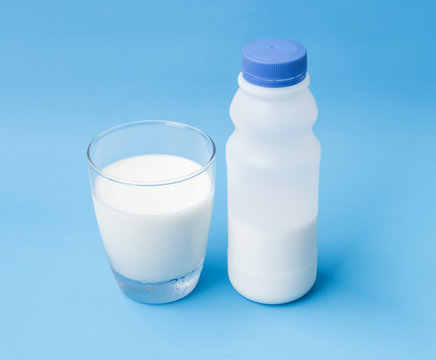 Glass and plastic bottle of milk on blue background, food and drink for healthy concept