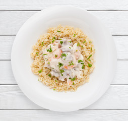 Pearl barley porridge with vegetable sauce top view. Healthy food, sport diet , lunch dish concept. White wooden planks background.