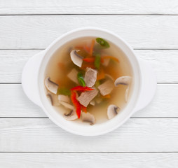 Dietary broth with vegetables and meat. Healthy food, slim body, lunch dish concept. White wooden planks background.