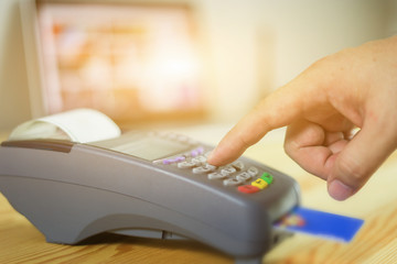 hand using credit card swiping machine entering credit card code to pay shopping online.creditcard swipe through terminal for payment in shop,buy and sell products & service,internet of things,vintage
