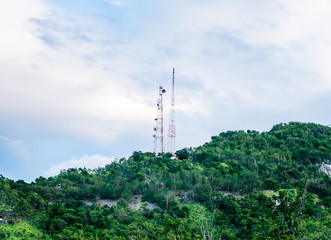 Telecommunication tower on the green forest on mountain