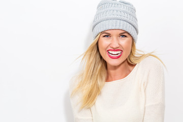 Happy young woman in winter clothes on a white background