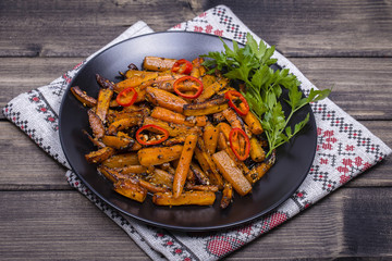 Roasted carrots in black plate, close up