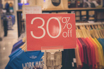 Red sale sign 30 percent discount on blurred background in a shopping mall of Bali, Indonesia, Asia.
