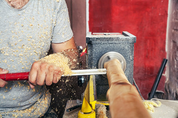 Man work on the lathe wood